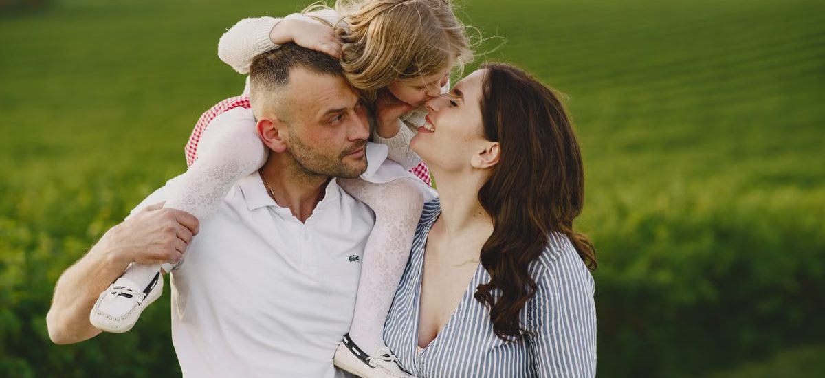 A delightful family moment captured in a lush scenic field, portraying love and happiness.