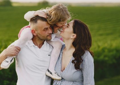 A delightful family moment captured in a lush scenic field, portraying love and happiness.