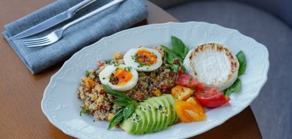 Delicious quinoa salad with sliced avocado, soft-boiled eggs, and fresh herbs.