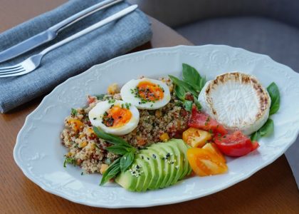 Delicious quinoa salad with sliced avocado, soft-boiled eggs, and fresh herbs.